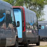 Amazon Prime delivery vans lined up for logistics operations in an urban setting.