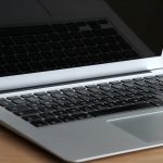 Close-up of a modern, sleek laptop resting on a wooden desk, emphasizing its portability and design.