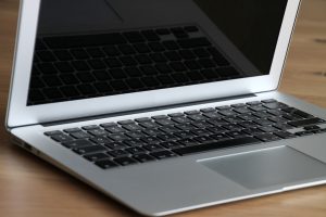 Close-up of a modern, sleek laptop resting on a wooden desk, emphasizing its portability and design.